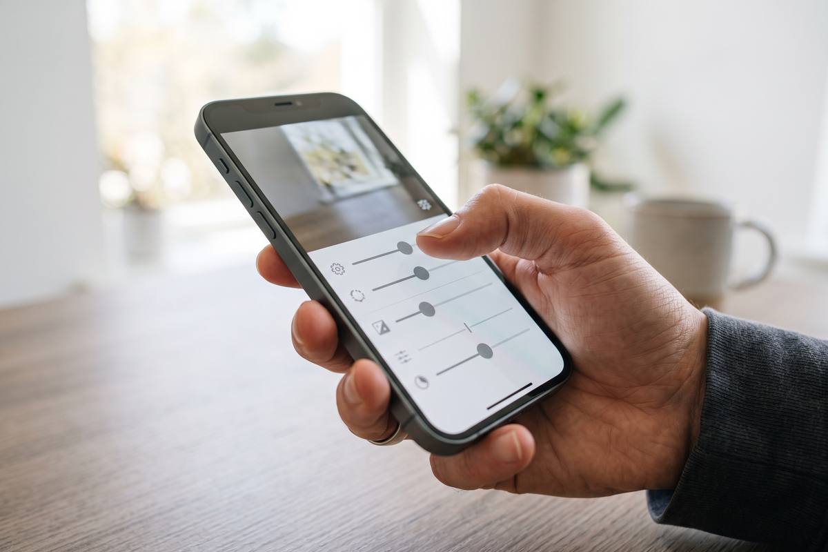 Hands filming a vertical scene with a smartphone outdoors
